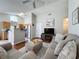 Bright living room with hardwood floors, a modern ceiling fan, and an open layout to the kitchen at 2692 Hemingway Ave, Haines City, FL 33844