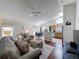Open living area with a fan, vaulted ceiling, view of the eat-in-kitchen, and lots of natural light at 2692 Hemingway Ave, Haines City, FL 33844