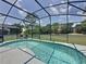 Tranquil screened-in pool with clear blue water, complemented by outdoor seating and serene surroundings at 2692 Hemingway Ave, Haines City, FL 33844