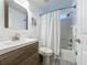 Bathroom with modern vanity and faucet, complemented by a shower with white tiled walls and patterned curtain at 2696 Hemingway Ave, Haines City, FL 33844