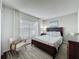 Bedroom featuring a wooden bed frame, bright window, stylish chair, and patterned bedding and decor at 2696 Hemingway Ave, Haines City, FL 33844
