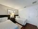 Bedroom featuring twin beds, wood-look flooring, and stylish decor and furnishings, with an accent wall at 2696 Hemingway Ave, Haines City, FL 33844