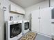 Bright laundry area with modern washer and dryer, white cabinets, and a patterned floor mat at 2696 Hemingway Ave, Haines City, FL 33844
