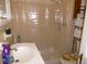 Compact bathroom with a shower featuring a plastic shower curtain and floral toilet seat at 302 S Palm Ave, Frostproof, FL 33843