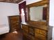 Traditional bedroom with hard wood floors, vintage dresser, and floral wallpaper border at 302 S Palm Ave, Frostproof, FL 33843