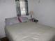 Simple bedroom with gray curtains, a window air conditioner, and a comfortable bed at 302 S Palm Ave, Frostproof, FL 33843