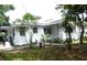 Quaint home featuring a well-manicured lawn and an inviting entrance with established landscaping at 302 S Palm Ave, Frostproof, FL 33843