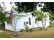 Exterior view of the home featuring a flag, tidy landscaping, and a well-maintained facade at 302 S Palm Ave, Frostproof, FL 33843