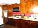 Functional kitchen with dark wood cabinetry, a retro style microwave, and red backsplash at 302 S Palm Ave, Frostproof, FL 33843