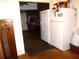An older style kitchen adjacent to a doorway, featuring a refrigerator at 302 S Palm Ave, Frostproof, FL 33843