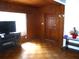 Bright living room with wood paneled walls, large window, and laminate wood floor at 302 S Palm Ave, Frostproof, FL 33843