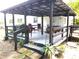 Relaxing covered patio with a variety of seating options and lush greenery at 302 S Palm Ave, Frostproof, FL 33843