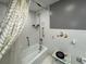 This bathroom features a shower with curtain, grab bars, updated fixtures, and tiled walls and floor at 400 W 4Th Ct, Frostproof, FL 33843