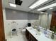 This is a bright, tiled bathroom featuring a large mirror, vanity, toilet, and a shower with a curtain at 400 W 4Th Ct, Frostproof, FL 33843