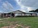 Charming brick home featuring a metal roof, neat landscaping, and a welcoming front porch at 400 W 4Th Ct, Frostproof, FL 33843