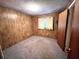 Bedroom with wood paneled walls, neutral carpeting, and a simple design at 405 S Shore Dr, Eagle Lake, FL 33839