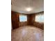Cozy bedroom features wood paneled walls and laminate flooring at 405 S Shore Dr, Eagle Lake, FL 33839