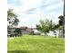 Waterfront property with lush green lawn and chain-link fence at 405 S Shore Dr, Eagle Lake, FL 33839