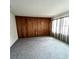 Cozy living room features wood paneling, neutral carpet, and ample natural light at 405 S Shore Dr, Eagle Lake, FL 33839