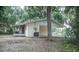 Charming home exterior with a carport, screened porch and lush trees at 4725 Kayworth Rd, Lake Wales, FL 33898