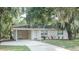 Charming single-story home featuring a covered parking area and mature trees draped with Spanish moss at 4725 Kayworth Rd, Lake Wales, FL 33898