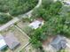 Overhead view of a home with a metal roof surrounded by mature trees and neighboring houses with fenced yards at 509 Mountain Dr, Babson Park, FL 33827