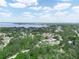An aerial view of a neighborhood by a body of water, with homes surrounded by lush trees on a sunny day at 509 Mountain Dr, Babson Park, FL 33827