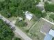 Aerial view of a home featuring a metal roof, mature trees, and a spacious yard in a quiet neighborhood at 509 Mountain Dr, Babson Park, FL 33827
