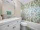 Bathroom with a vanity, toilet, tub, and shower with decorative citrus patterned curtain at 509 Mountain Dr, Babson Park, FL 33827