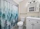 Bathroom featuring a shower with curtain, toilet, and vanity with sink and cabinet at 509 Mountain Dr, Babson Park, FL 33827