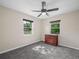 Bedroom with carpet flooring, light walls, ceiling fan and windows with backyard views at 509 Mountain Dr, Babson Park, FL 33827