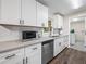 Bright kitchen featuring white cabinets, stainless steel appliances, granite countertops, and a view to the laundry room at 509 Mountain Dr, Babson Park, FL 33827