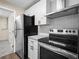 Updated kitchen featuring white cabinets, stainless steel appliances, granite countertops, and modern fixtures at 509 Mountain Dr, Babson Park, FL 33827