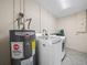 Functional laundry room equipped with a water heater, washing machine, and dryer for convenience at 509 Mountain Dr, Babson Park, FL 33827