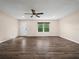 Bright living room featuring wood floors, a ceiling fan, a front door, and a large window with a pleasant view at 509 Mountain Dr, Babson Park, FL 33827