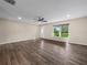 Bright and spacious living room featuring wood floors, a ceiling fan, and a large window with a pleasant view at 509 Mountain Dr, Babson Park, FL 33827