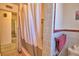 Cozy bathroom featuring a pink bathtub, white tiles, and mosaic flooring, exuding classic charm at 509 N Scenic Hwy, Frostproof, FL 33843
