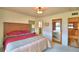 Cozy bedroom with a wood headboard, warm lighting, carpet floors, and access to the bathroom and kitchen at 509 N Scenic Hwy, Frostproof, FL 33843