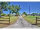 Property with an expansive driveway, mature trees, fenced-in yard, and green lawn at 509 N Scenic Hwy, Frostproof, FL 33843
