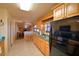 Bright kitchen with maple cabinets, green countertops, tile floor, and black refrigerator at 509 N Scenic Hwy, Frostproof, FL 33843