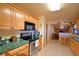 Functional kitchen featuring maple cabinets, green countertops, and stainless steel appliances at 509 N Scenic Hwy, Frostproof, FL 33843