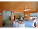 Cozy sunroom with wood-paneled walls, a ceiling fan, and an abundance of natural light from large windows at 509 N Scenic Hwy, Frostproof, FL 33843