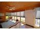 Bright sunroom featuring wood paneling, large windows with blinds, and tiled flooring at 509 N Scenic Hwy, Frostproof, FL 33843