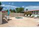 Community hot tub with chairs, table, and blue umbrella for shade at 6201 Country Club Dr # 21, Lake Wales, FL 33898