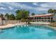 Community pool with chairs, lush landscaping, and residential building in the background at 6201 Country Club Dr # 21, Lake Wales, FL 33898