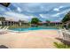 Community pool with plenty of lounge chairs and lush landscaping by the residential buildings on a beautiful day at 6201 Country Club Dr # 21, Lake Wales, FL 33898