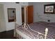 Bedroom with a plaid bedspread, window, mirror, closet door and framed art at 7 Lamplight Ln, Winter Haven, FL 33884