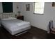 Simple bedroom featuring a bed, nightstand, window, and laminate wood flooring at 7 Lamplight Ln, Winter Haven, FL 33884
