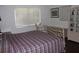 Bedroom with a plaid bedspread, window, dresser, and wicker cabinet at 7 Lamplight Ln, Winter Haven, FL 33884