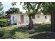 The exterior showcases a quaint backyard patio accessible through a gate and shaded by mature trees at 7 Lamplight Ln, Winter Haven, FL 33884